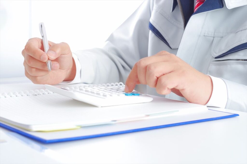 電卓で計算する男性